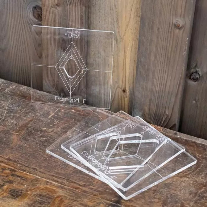 Clear acrylic diamond-shaped woodworking templates on a rustic wooden table