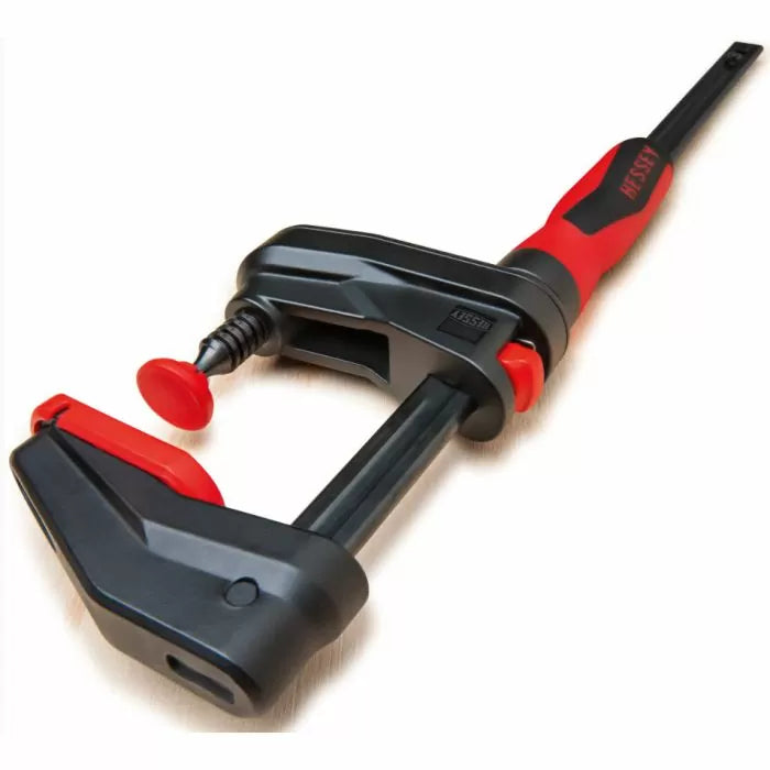 Woodworking parallel clamp with red and black handle on light background