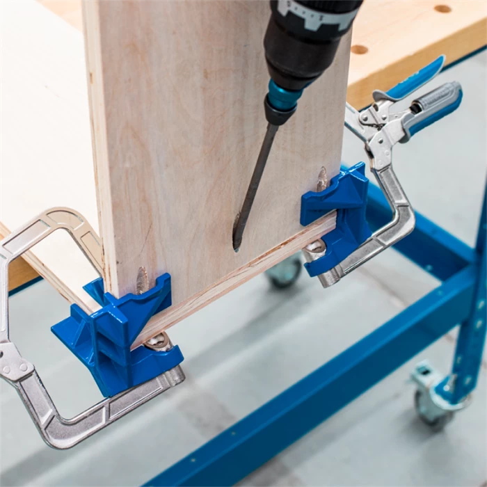 Pocket hole drilling jig clamps holding wood panels for precise woodworking joinery
