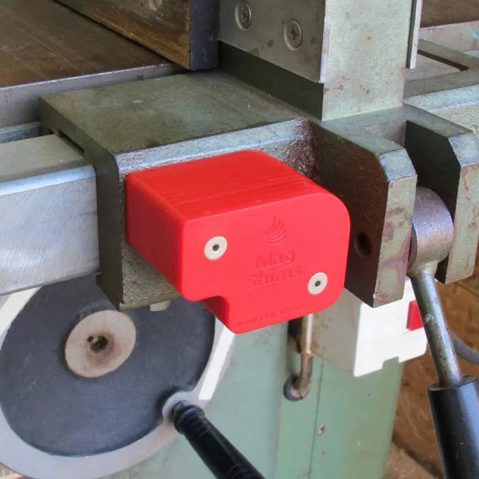 Red Mag Shims woodworking shim on metal jointer fence in workshop setting