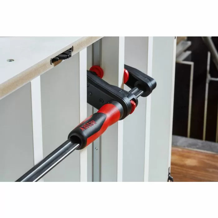 Bar clamp securing wood panels during woodworking assembly