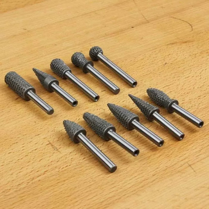 Set of rotary burr bits for woodworking on a wooden surface, various shapes and sizes