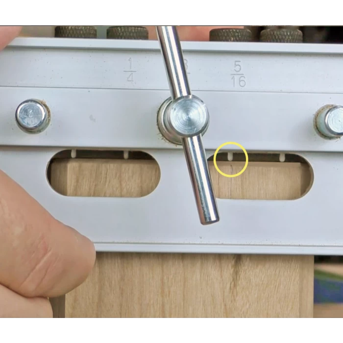 Woodworking alignment jig with metal guide and adjustment handle on wood piece