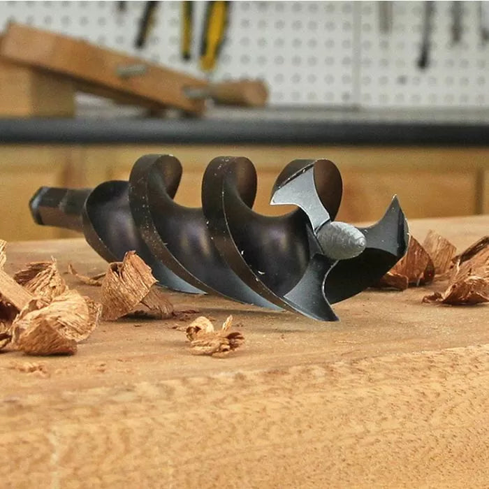 Close-up of auger drill bit for woodworking with wood shavings on a workbench