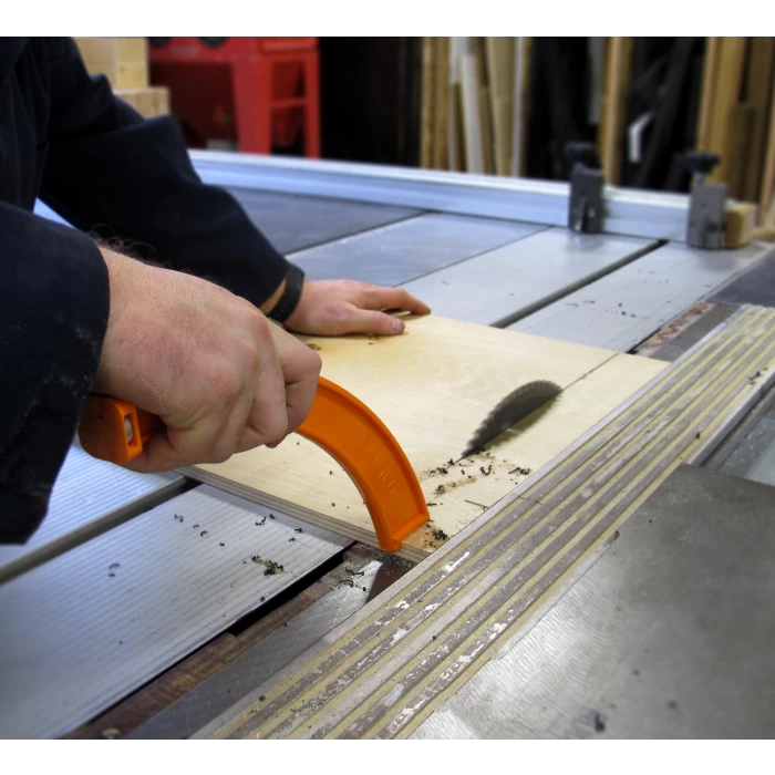 Using a table saw with a push block to cut wood for precise woodworking safety