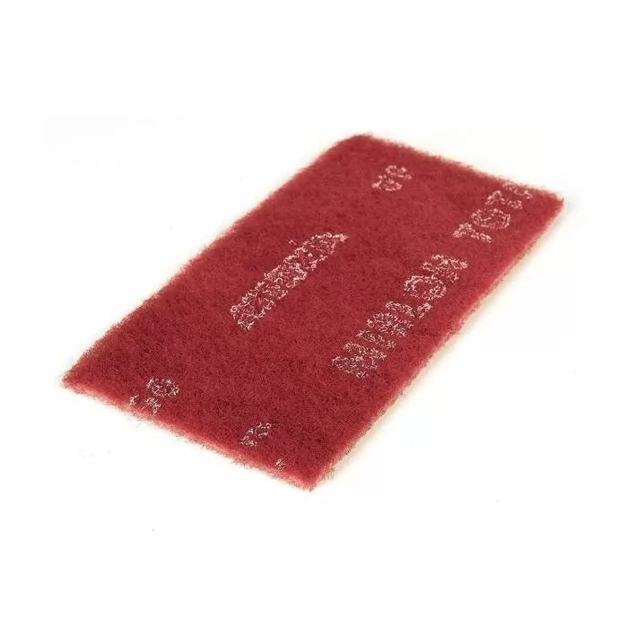 Maroon non-woven abrasive sanding pad for woodworking finishing tasks on white background