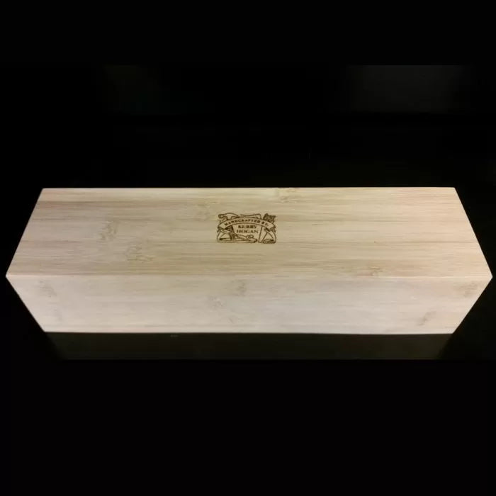 Rectangular wooden sharpening stone box with engraved logo on lid, set against black background