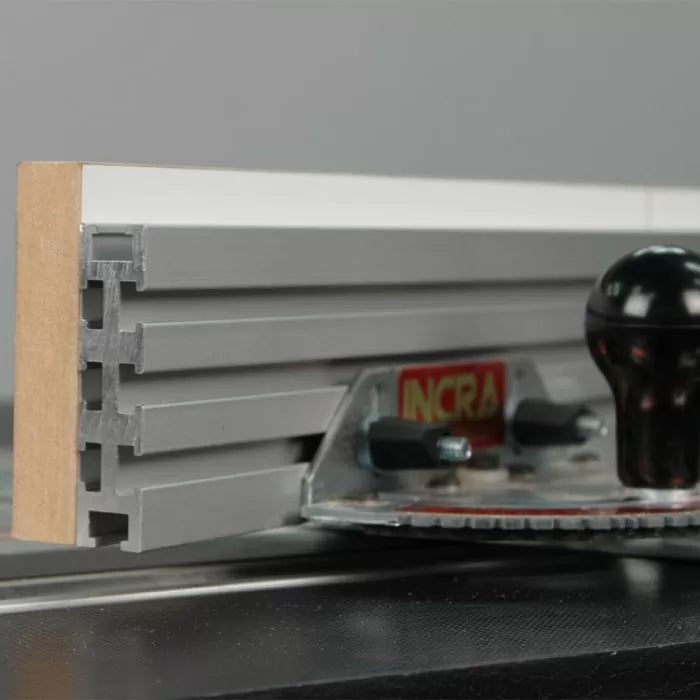 Close-up of aluminum router table fence with T-slots and adjustment knobs, woodworking tool