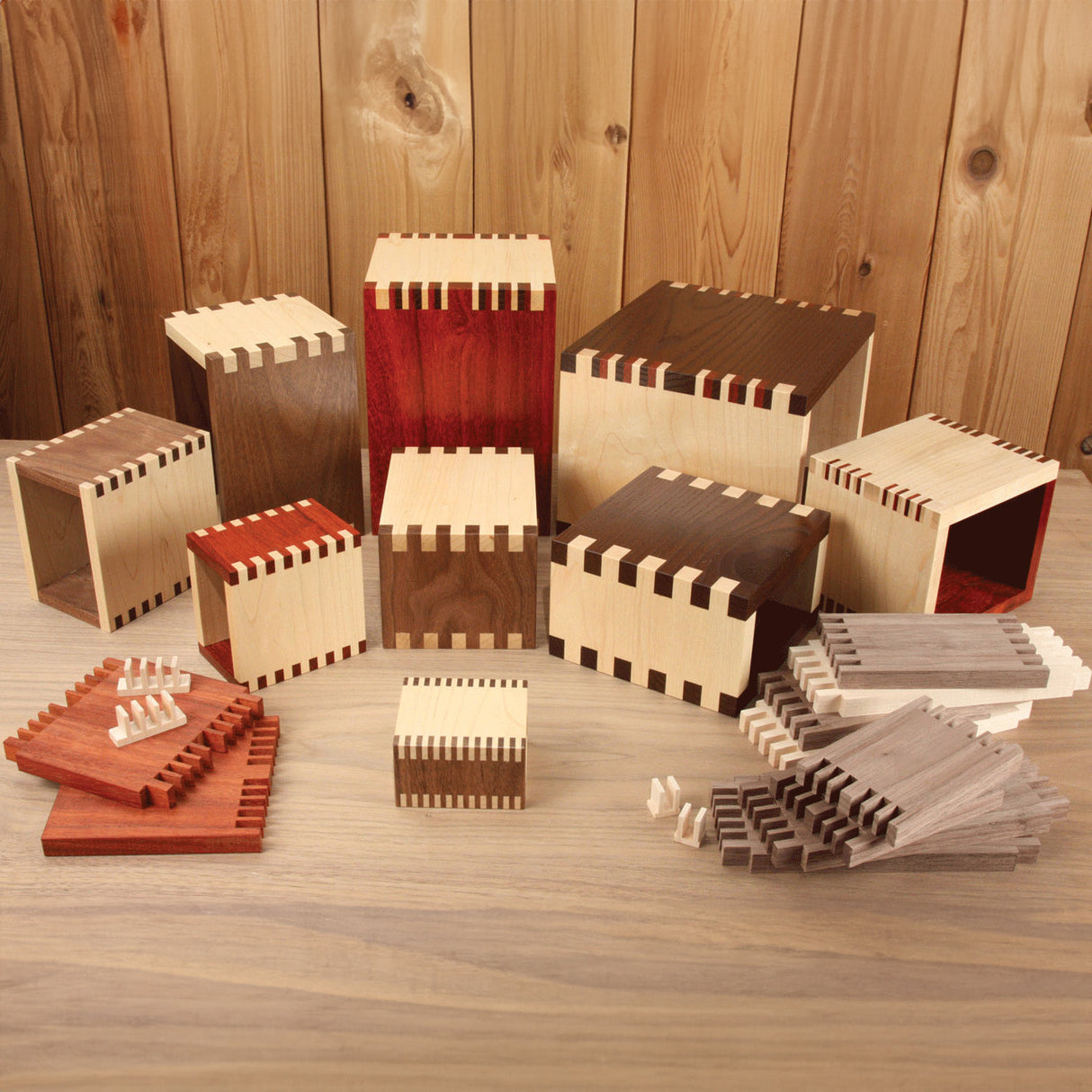 Assorted wooden boxes and panels with precision finger joints on a workbench