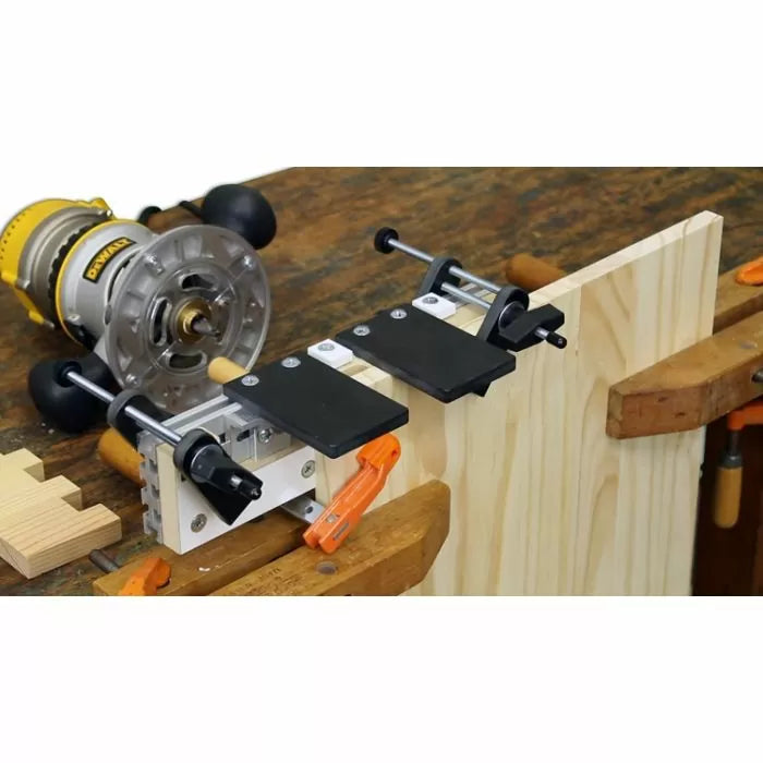 Woodworking dovetail jig clamped to workbench with router and wood board