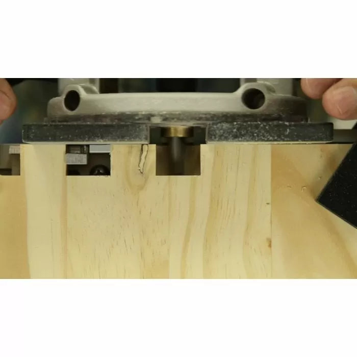Wood router cutting dovetail joint in light wood board for woodworking project