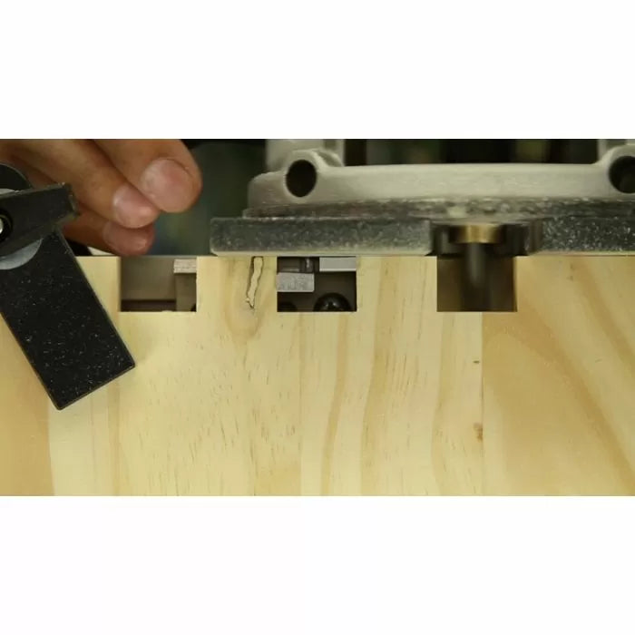 Wood router cutting dovetail joints in light wood with jig for woodworking precision