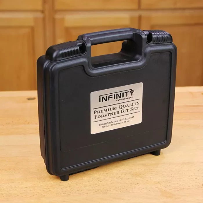 Black hard plastic case labeled Premium Quality Forstner Bit Set on wood workshop table.