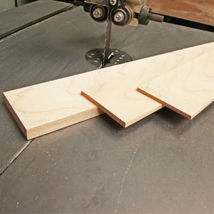 Bandsaw cutting straight, clean lines in hardwood board on workshop table