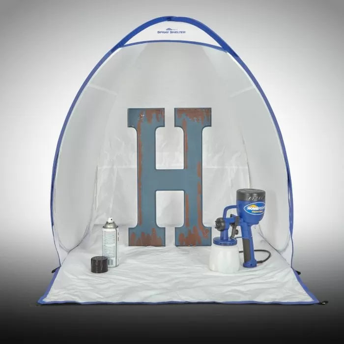 Portable spray shelter with painted wooden letter H, spray paint can, and paint sprayer inside