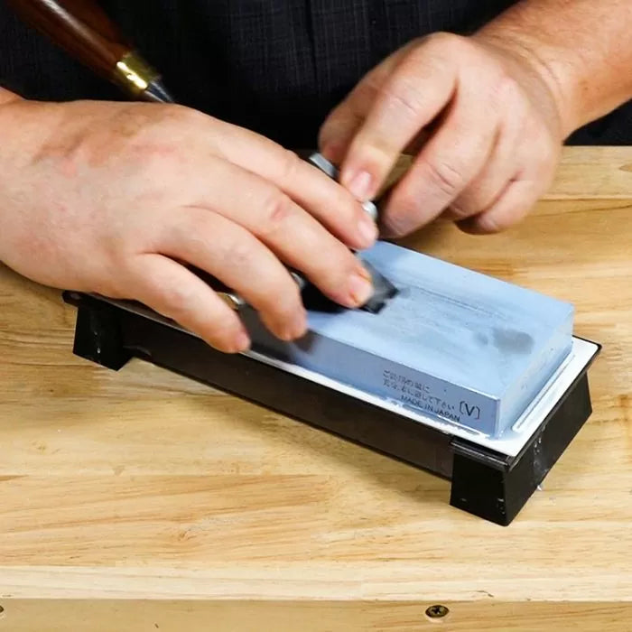 Sharpening a woodworking chisel on a whetstone for precise edge maintenance
