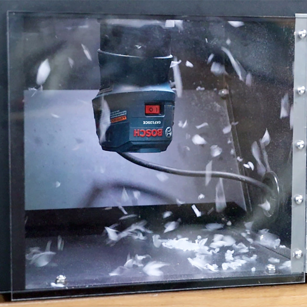 Router with dust collection in enclosure, surrounded by wood shavings, woodworking tool