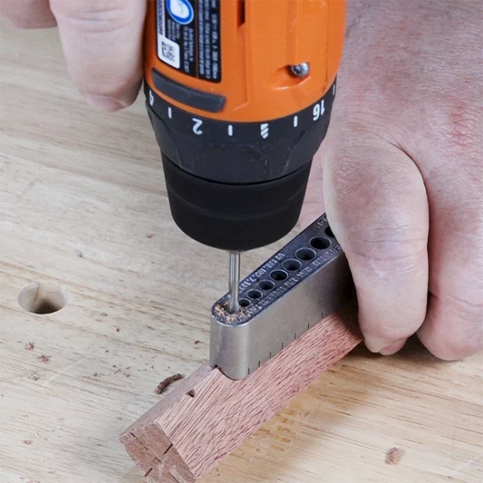 Drill guide jig used with cordless drill for precise corner hole drilling in woodwork