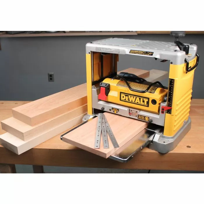 Benchtop thickness planer with yellow casing, wood boards, and metal planer blades