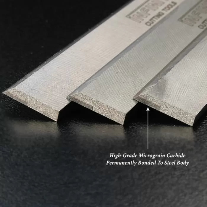 Close-up of woodworking carbide planer blades showing micrograin carbide edges bonded to steel bodies