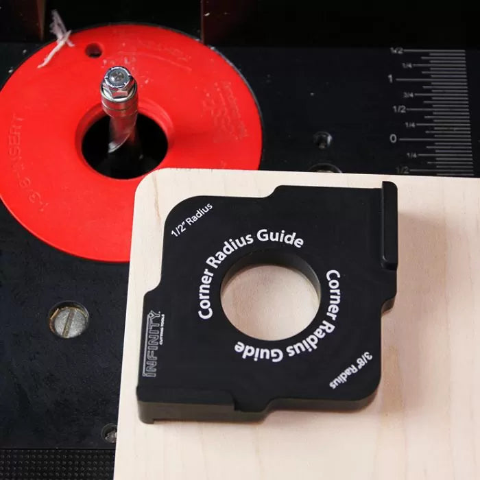 Corner radius guide tool on wood board next to router table with red insert and ruler markings