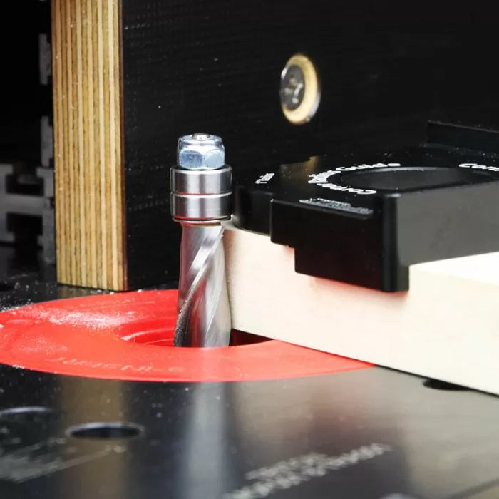 Close-up of a router table with a spiral router bit cutting a piece of wood for woodworking