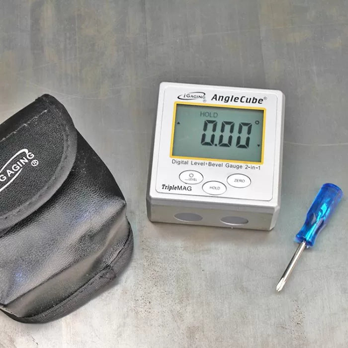 Digital angle gauge with carrying pouch and small screwdriver on a metal surface