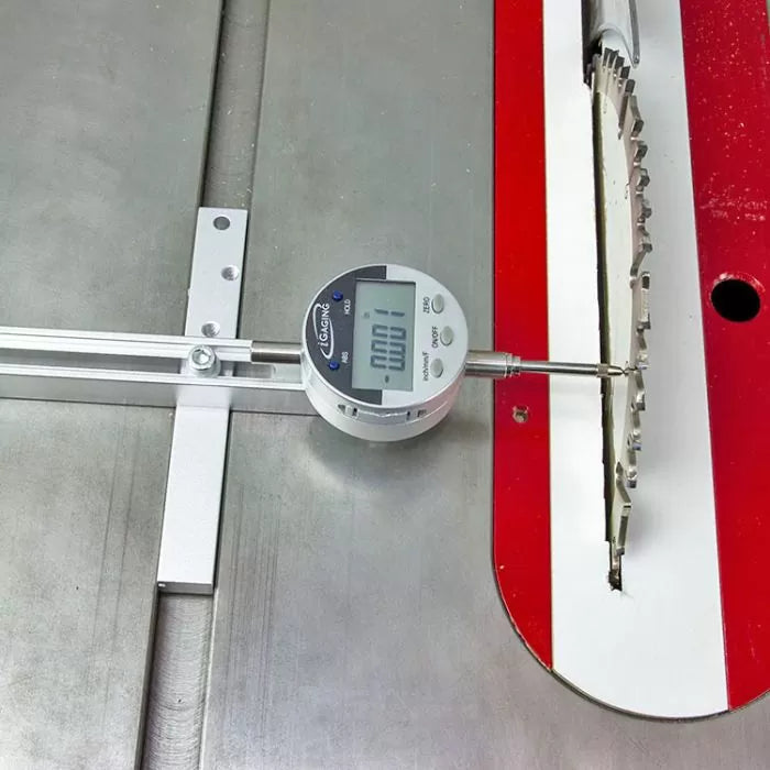 Digital dial indicator measuring table saw blade alignment on a metal saw table