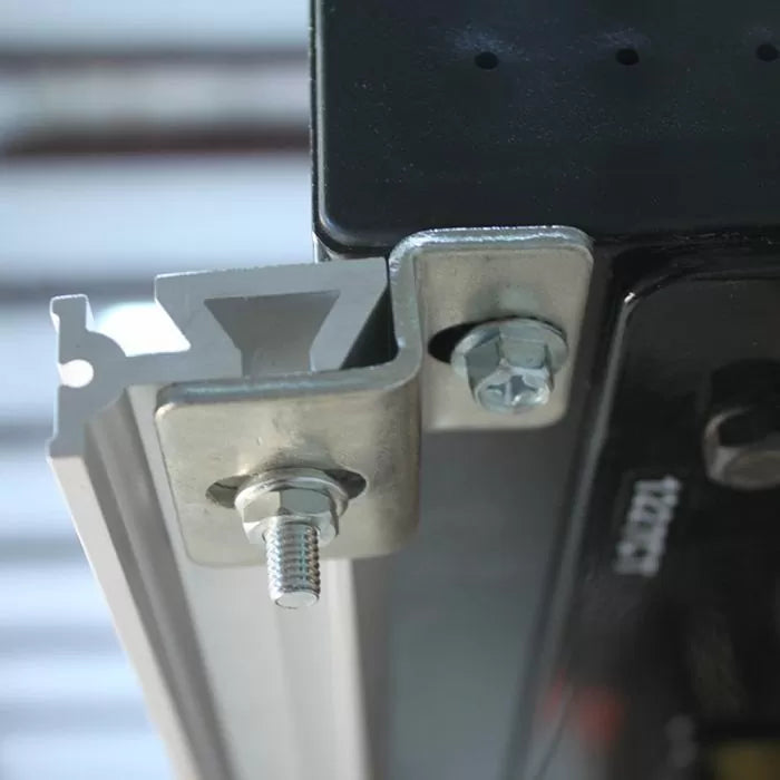 Close-up of a metal T-track fence clamp bracket with bolts for woodworking router table