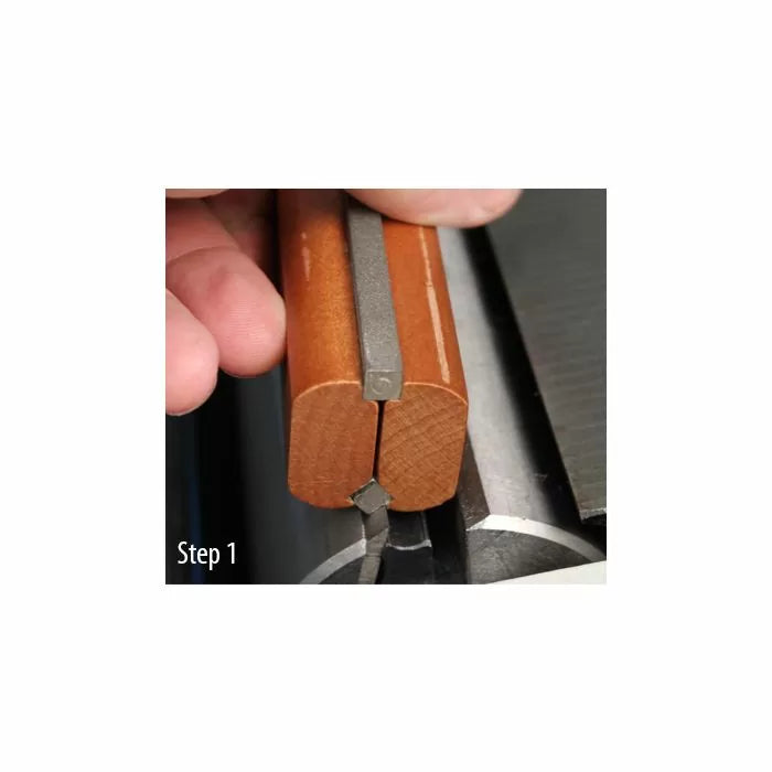 Woodworker holding honing guide on jointer knife for blade sharpening, step 1