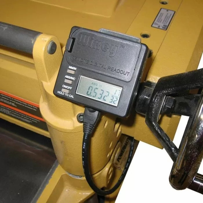 Digital planer gauge with LCD readout attached to woodworking machine