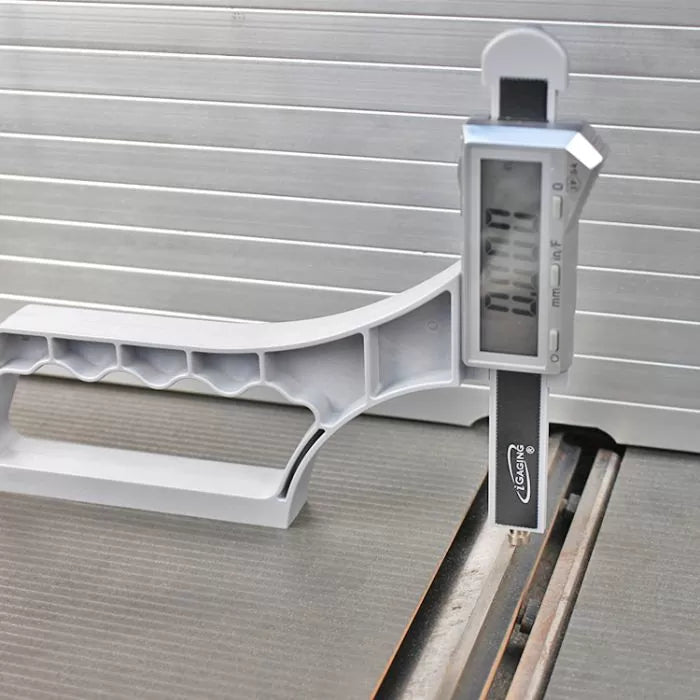 Digital caliper measuring table saw blade height on aluminum surface