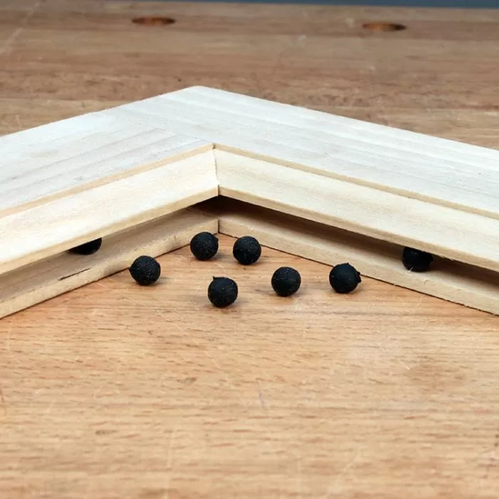 Corner wood joint with black biscuits for woodworking joinery on a workbench