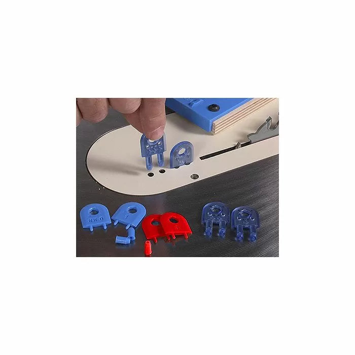 Assorted table saw insert leveling screws and shims in blue and red near a saw blade slot.