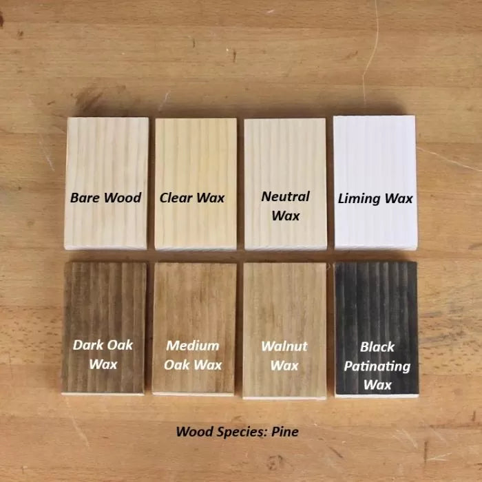 Comparison of pine wood finish samples showing effects of bare wood, clear wax, neutral wax, liming wax, dark oak wax, medium oak wax, walnut wax, and black patinating wax on a wood surface.