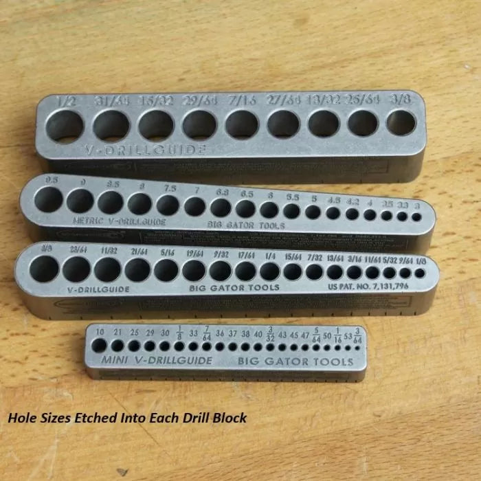 Assorted metal drill guides and blocks with etched hole sizes on wood surface