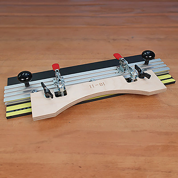 Woodworking router table jig with aluminum rails and clamps on a wooden surface