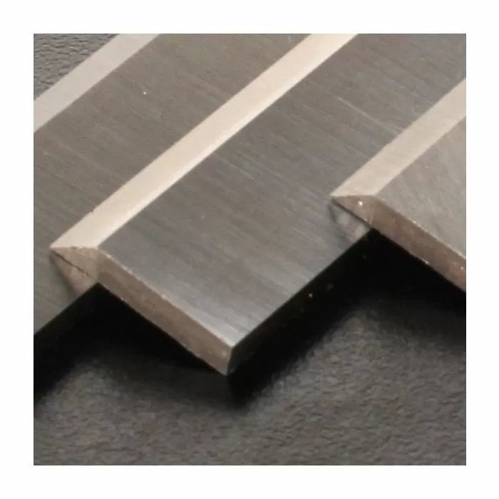 Close-up of sharp carbide woodworking planer blades on a dark surface