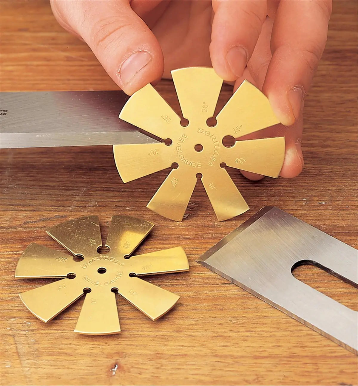 Brass bevel gauge measuring chisel angle on wooden surface, woodworking hand tool