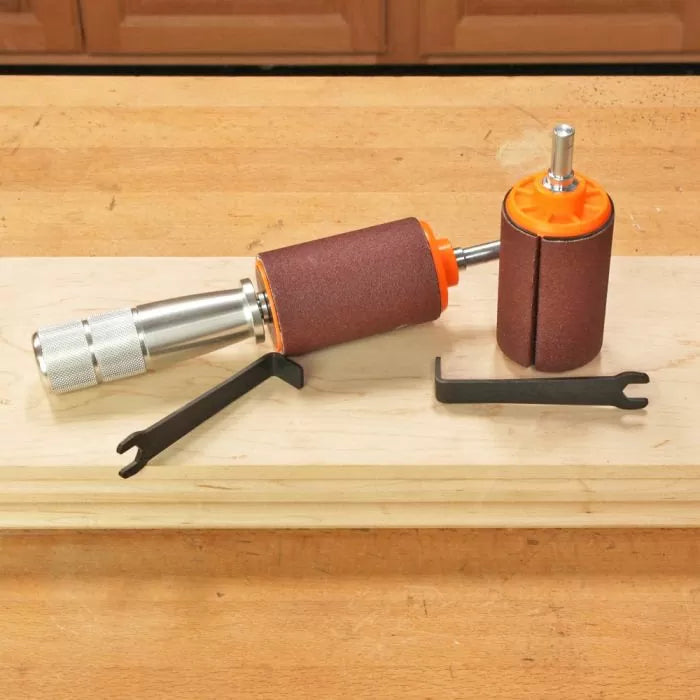 Drum sander kit with sanding drums and wrenches on a wooden workbench