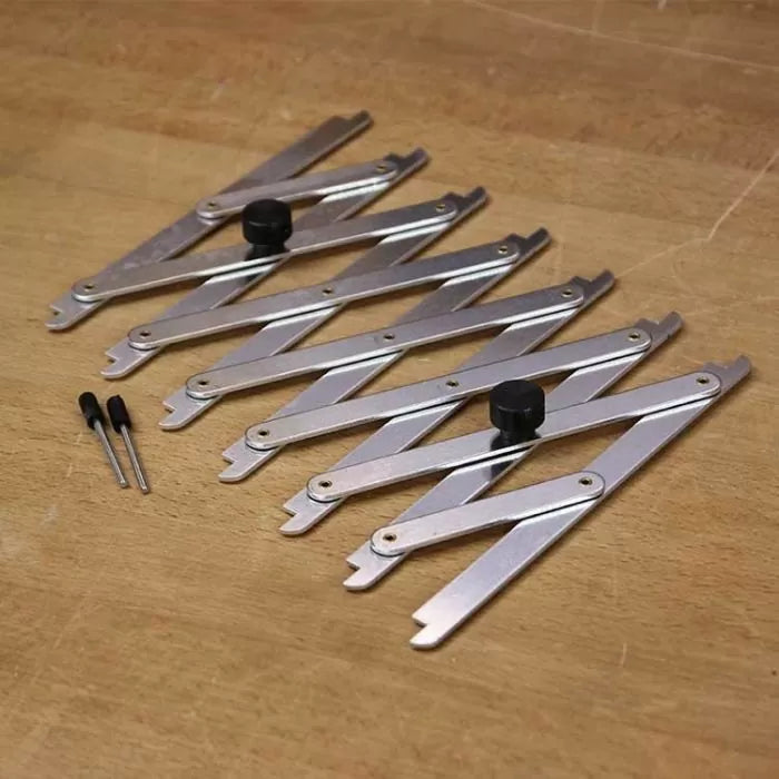 Adjustable woodworking layout tools with metal arms and black knobs on a wood workbench