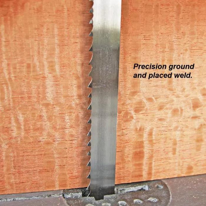 Close-up of bandsaw blade cutting hardwood, showing precision ground and placed weld.
