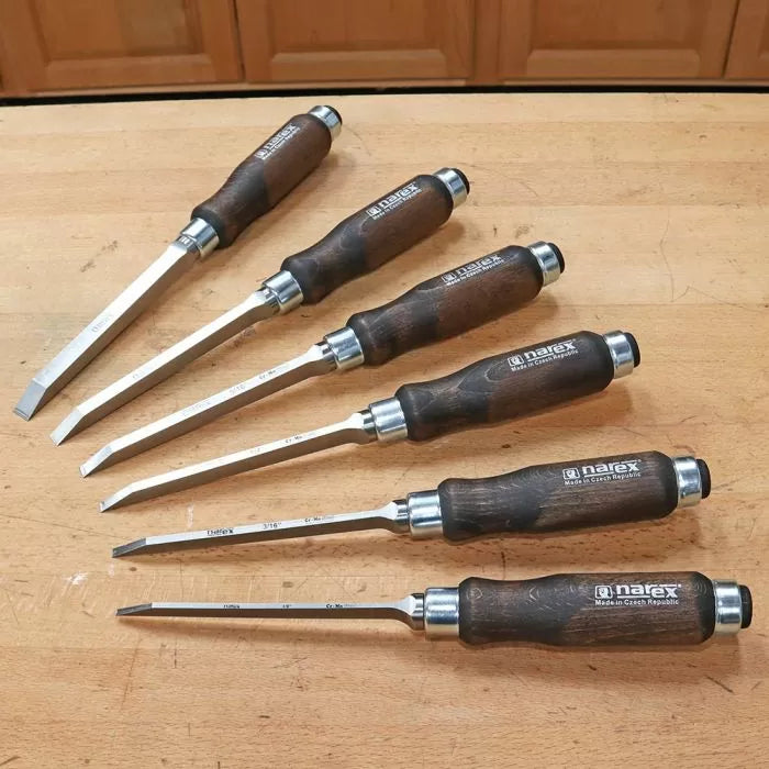 Set of six Narex woodworking chisels with dark wood handles on a workbench surface