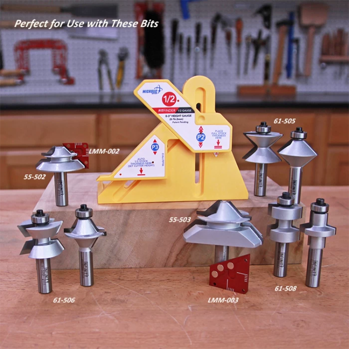 Woodworking router bits and a yellow gauge tool displayed on a workbench in a workshop.