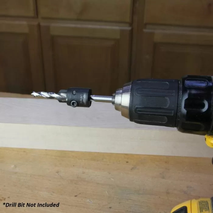 Drill with attached quick-change bit adapter for woodworking on a workshop table