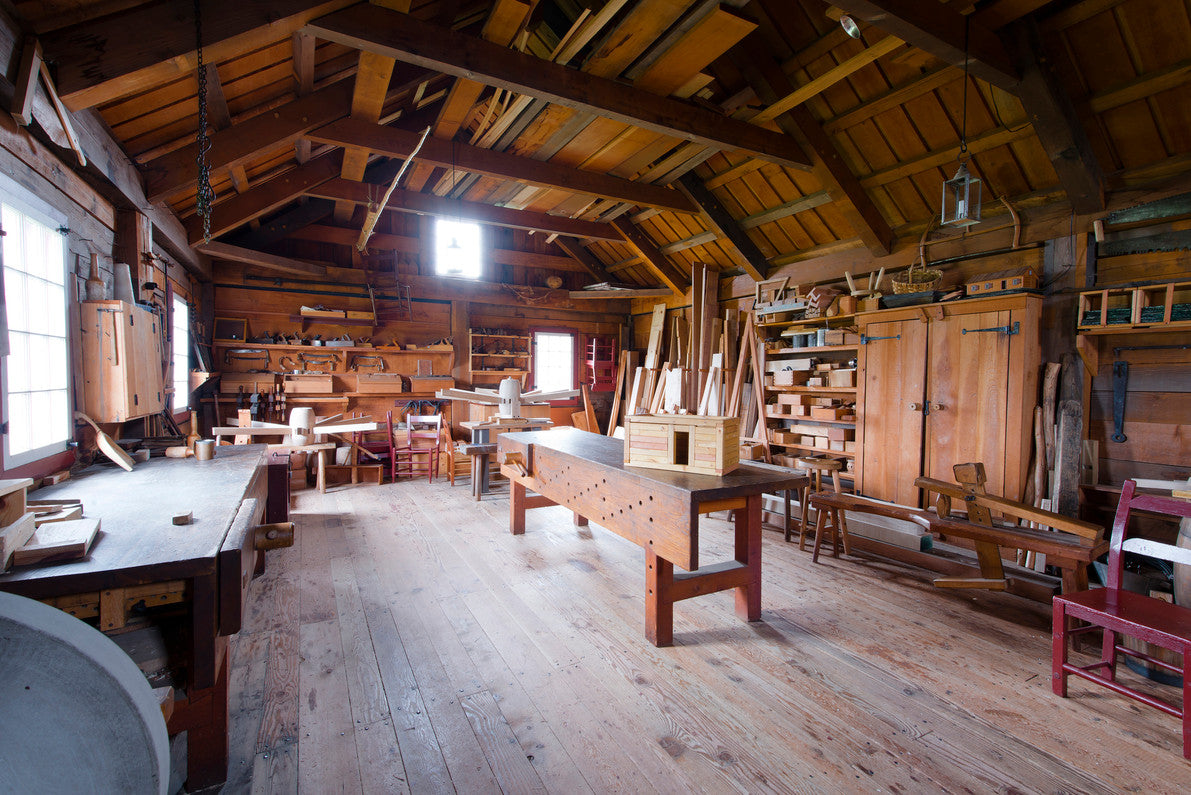 Woodworking shop with workbenches, wooden tools, and natural light, emphasizing carpentry tools