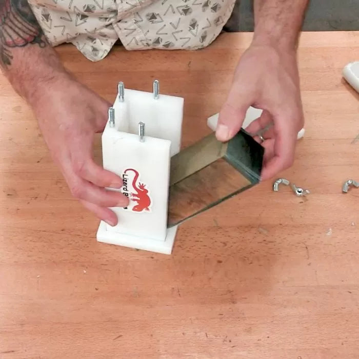 Man assembling woodworking jig with acrylic panels and bolts on a workbench