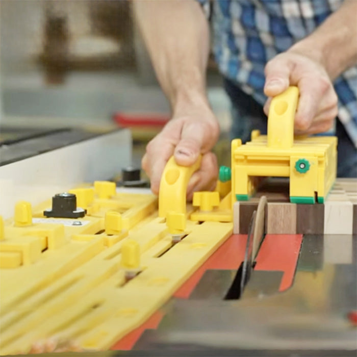 Man using yellow table saw push block and featherboard for safe woodworking