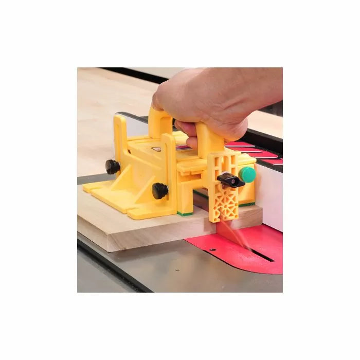 Yellow table saw push block guiding wood for safe and precise cutting in woodworking shop