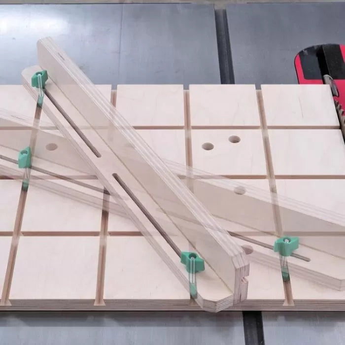 Woodworking table saw sled with adjustable guides and clamps on a slotted work surface.
